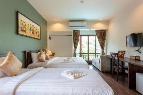 a hotel room with two beds and a desk at The La-Ngu Boutique in Langu