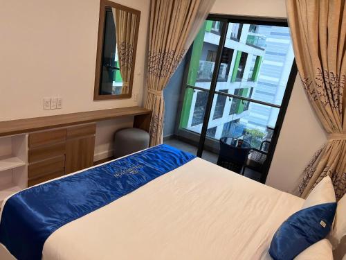 a bedroom with a bed and a large window at Republic Plaza - View sân bay, view hồ bơi in Ho Chi Minh City