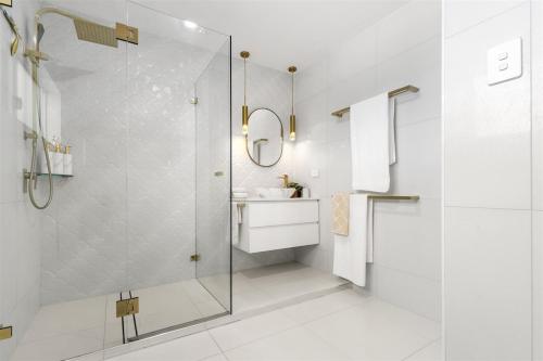 a bathroom with a glass shower and a sink at Luxury Pool Retreat Ocean & Mountain Views in Scarborough