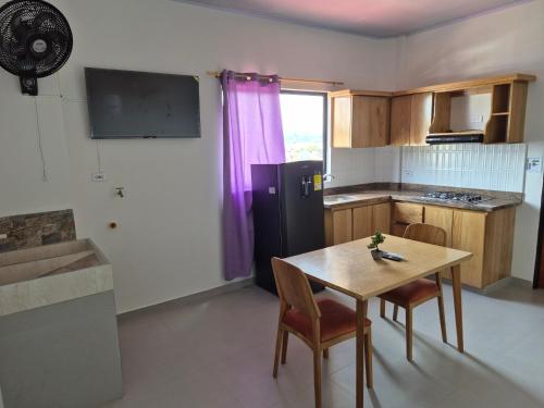 ネコクリにあるAPARTAMENTO MAR CARiBEのキッチン(テーブル、黒い冷蔵庫付)