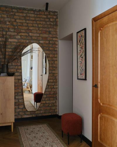 a room with a mirror on a brick wall at Апартаменты Золотой квадрат in Almaty