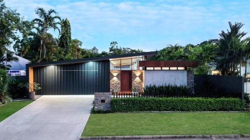 una casa con fachada negra con césped en Casa Ponta Port Douglas, en Craiglie