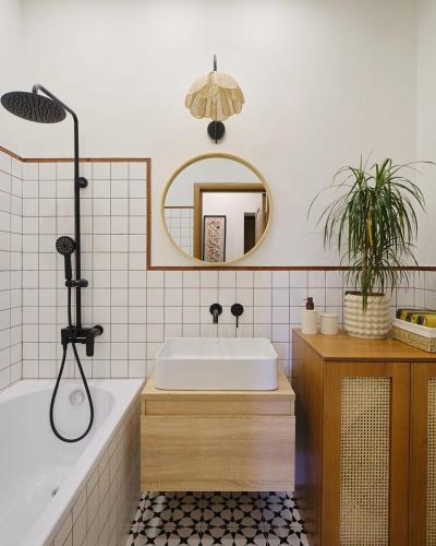 a bathroom with a tub and a sink and a mirror at Апартаменты Золотой квадрат in Almaty