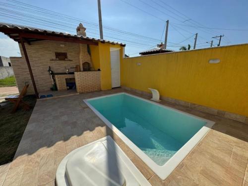 une piscine dans l'arrière-cour d'une maison dans l'établissement Casa de praia em Cabo Frio, à Cabo Frio