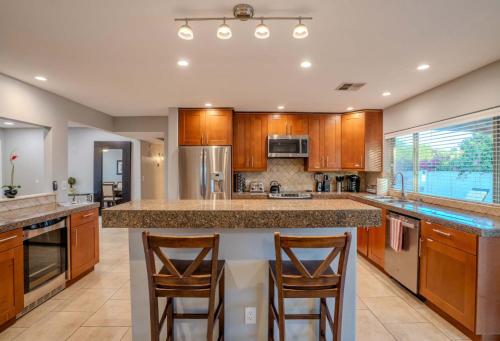 a kitchen with a large island with two bar stools at 3bdr Remodeled Scottsdale Desert Pool Oasis and Entertainment in Phoenix