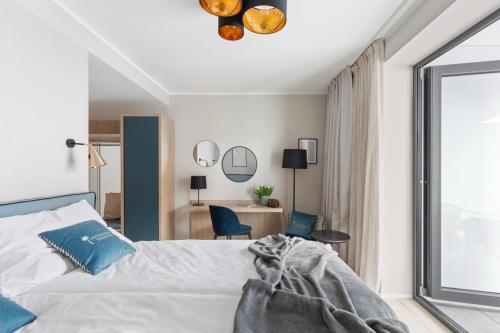 a bedroom with a bed and a desk and a window at Living Ascona Boutique Hotel in Ascona