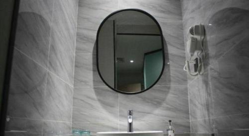 吉安市にあるBorrman Hotel Ji'an Railway Station Jinggangshan Universityの鏡と洗面台のあるバスルーム