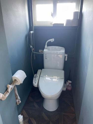 a bathroom with a white toilet in a blue room at Bear Foot 蒼 in Yakumo