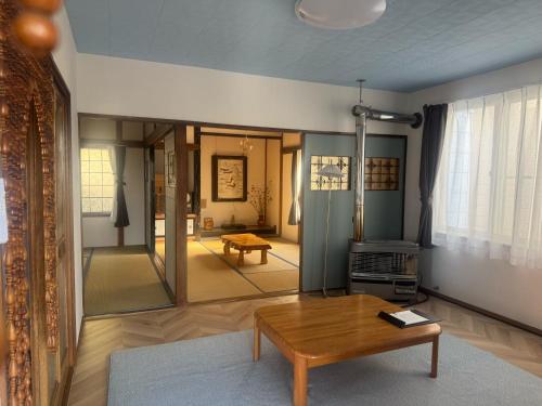 a living room with a table and a mirror at Bear Foot 蒼 in Yakumo