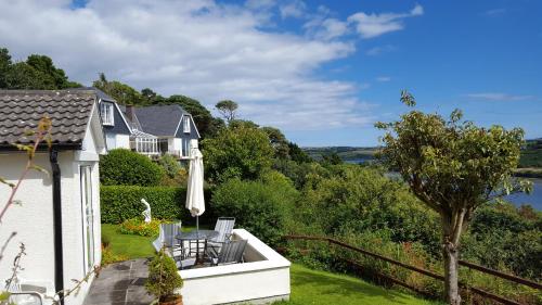 a house with a balcony with a table and chairs at Rocklands House Bed and Breakfast in Kinsale