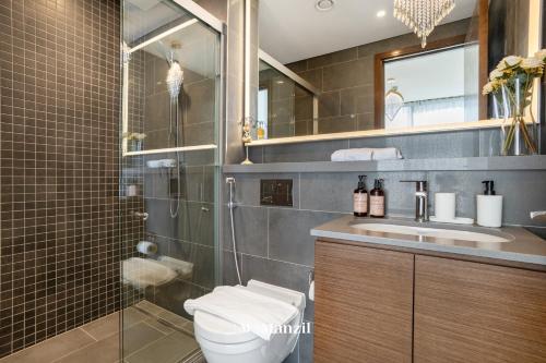 a bathroom with a toilet and a shower and a sink at Manzil - Luxury 1BR in Sobha Hartland w Pool & Gym Access in Dubai