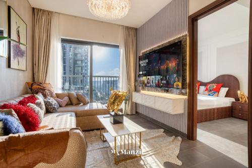 a living room with a couch and a tv at Manzil - Luxury 1BR in Sobha Hartland w Pool & Gym Access in Dubai