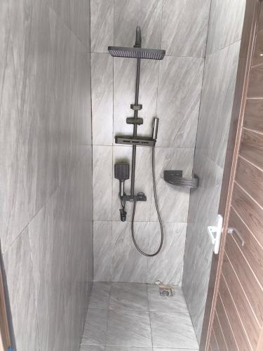 een douche met een douchekop in een badkamer bij Deju Cabin with Private Pool & Mountain View in Cilama