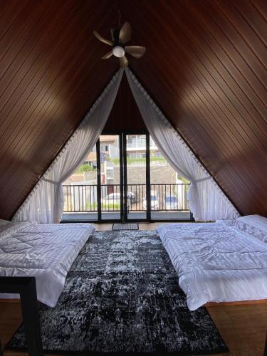 een slaapkamer met een bed en een plafondventilator bij Deju Cabin with Private Pool & Mountain View in Cilama