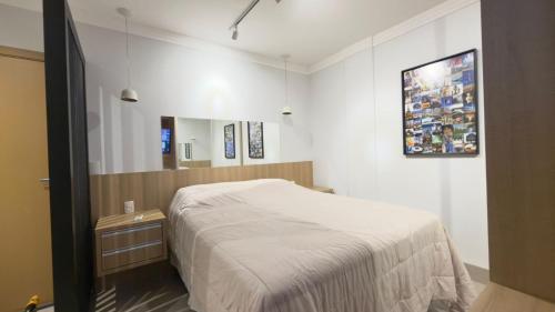 a small bedroom with a bed and a mirror at Studio Inn Rami in Uberlândia