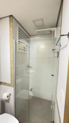a glass shower in a bathroom with a toilet at Studio Inn Rami in Uberlândia