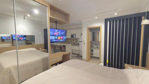 Un dormitorio con dos camas y un televisor. en Studio Inn Rami, en Uberlândia