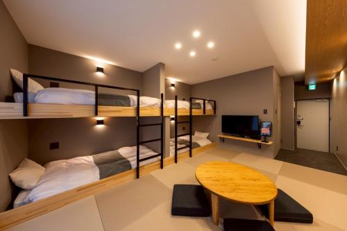 een kamer met 2 stapelbedden en een tafel bij STAY THE RINKU BAY Apartment Hotel in Izumi-Sano