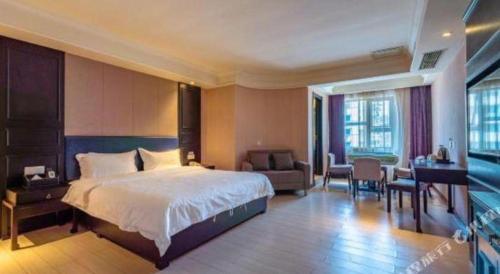a hotel room with a large bed and a desk at Super 8 Hotel Guiyang Qianling Park Ruijin North Road in Guiyang
