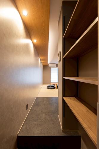 a room with a hallway with shelves and a table at STAY THE RINKU BAY Apartment Hotel in Izumi-Sano