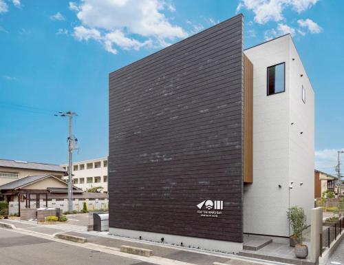 een zwart-wit gebouw aan de straatkant bij STAY THE RINKU BAY Apartment Hotel in Izumi-Sano