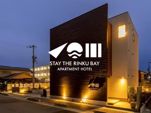 a sign for stay the rhino bay apartment hotel at STAY THE RINKU BAY Apartment Hotel in Izumi-Sano