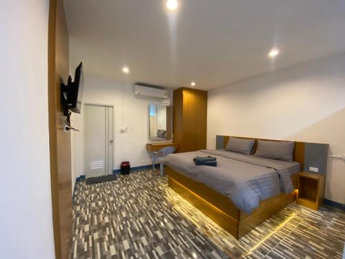 a bedroom with a bed and a television in it at Pun's Garden Home in Ban Sao Thong