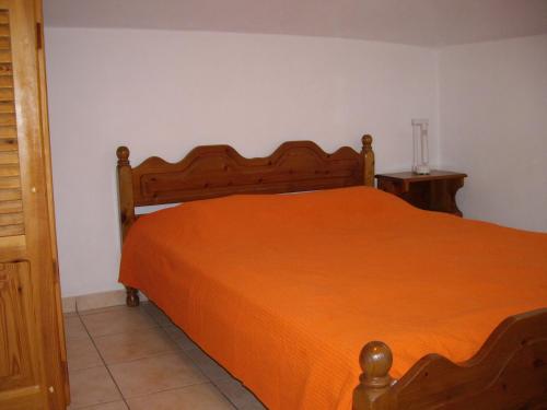 a bedroom with a bed with an orange bedspread at Splantza Apartments in Ammoudia