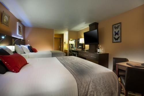 a hotel room with two beds and a television at Prospector Hotel & Casino in Ely