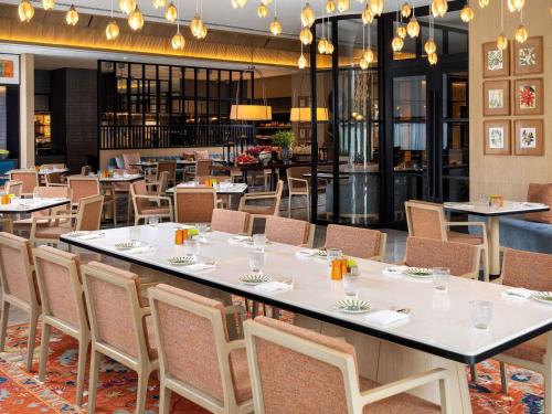 a large dining room with tables and chairs at Pullman Chennai Anna Salai - Premium Brand By Accor in Chennai
