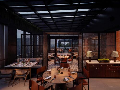 a rendering of a restaurant with tables and chairs at Pullman Chennai Anna Salai - Premium Brand By Accor in Chennai