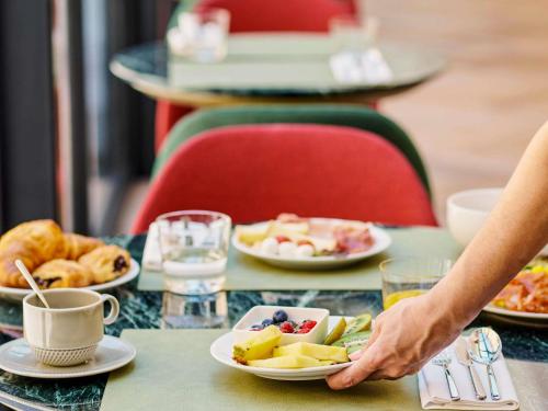 阿尔巴Hotel Giacomo Morra Alba - Handwritten Collection的桌上拿着一盘食物的人