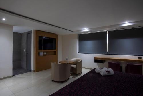 a room with a table and chairs and a bathroom at Hotel San Lorenzo in Mexico City