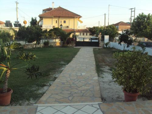 a walkway in front of a house with a yard at Splantza Apartments in Ammoudia