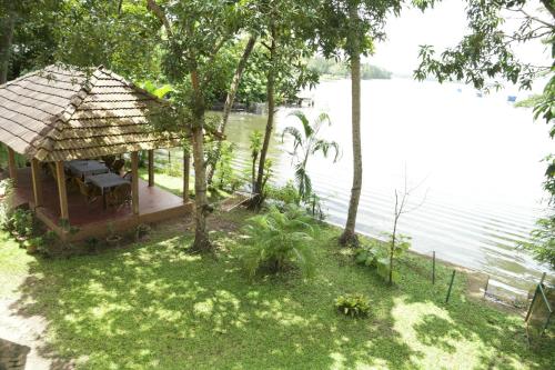 a small gazebo next to a body of water at Lovedale Lakeside Homestay in Alleppey