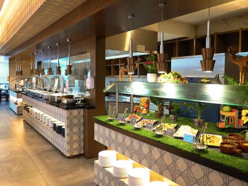 ドバイにあるNovotel Dubai Gold Districtのレストランのビュッフェラインで食べ物を注文する