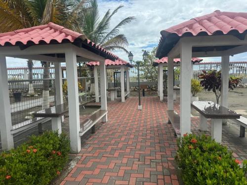 プラヤスにあるCasa en urbanización privada a 2 minutos caminando de la playa, Vía a Dataのビーチにあるベンチのあるレンガの歩道