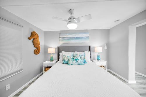 a white bedroom with a bed and two night stands at Dolphin House Rental Vacation in Fort Myers Beach