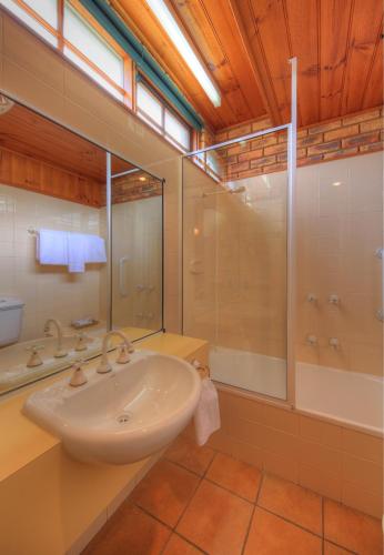 a bathroom with a sink and a shower at Stanley Village Waterfront Accommodation in Stanley