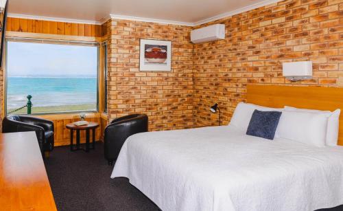 a hotel room with a bed and a large window at Stanley Village Waterfront Accommodation in Stanley