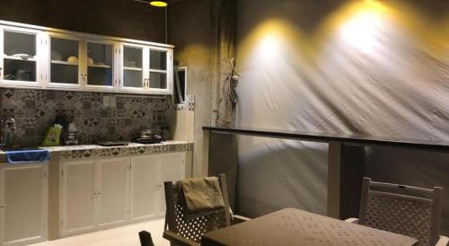 a kitchen with white cabinets and a table and chairs at Laverne Hotel in Ho Chi Minh City