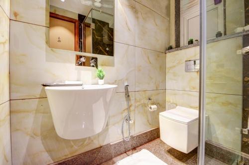 un baño con lavabo e inodoro en J Residency Near Nizamuddin Railway Station, en Nueva Delhi