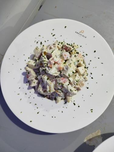 a white plate with a salad on a table at Greyfield Hotel and Apartments in Benin City