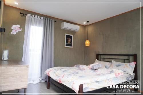 ein Schlafzimmer mit einem Bett und einem Fenster in der Unterkunft Casa Decora in Bamban
