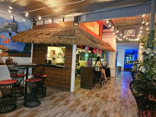 a restaurant with a bar with a woman sitting at a table at wombats beach resort,hotel, bar and restaurant in Olongapo