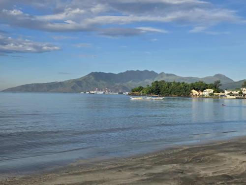 a view of a beach with mountains in the background at wombats beach resort,hotel, bar and restaurant in Olongapo