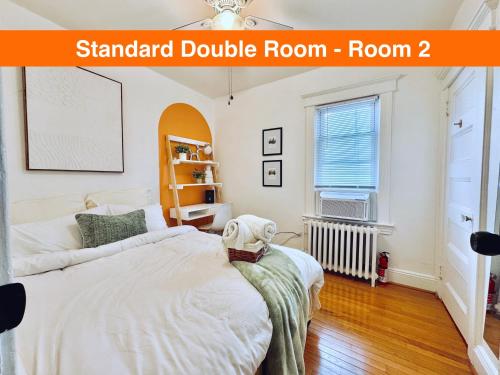 Un dormitorio con una gran cama blanca y una ventana. en 20 min NYC-Modern Private Room-Queen Bed-Parking, en Jersey City