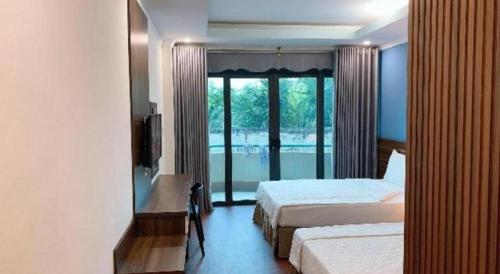 a bedroom with two beds and a view of a pool at Hon Ngu Hotel Cua Lo Beach in Dong Quan
