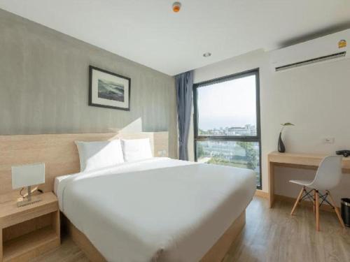 a bedroom with a large white bed and a large window at B2 Don Mueang Premier Hotel in Bangkok
