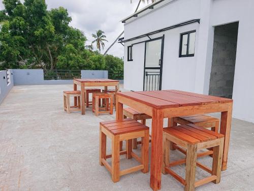 three picnic tables and benches in front of a building at Crescent Bay Weligama in Weligama